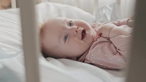 Baby Girl Smiling in Crib