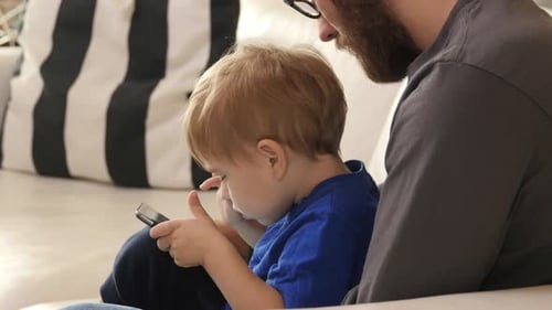 Boy Using Tablet with Father in Home Setting