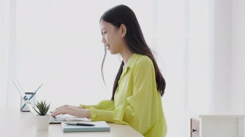 Young asian businesswoman working on laptop computer on desk at home office.