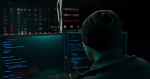 Young Adult Working At Multiple Computer Screens