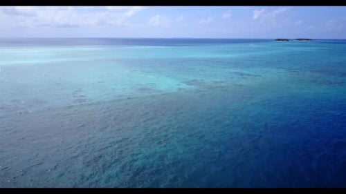 Aerial top view scenery of idyllic shore beach adventure by clear ocean and bright sand background o