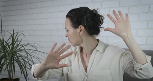 Woman Raises Hands in a Stopping Gesture