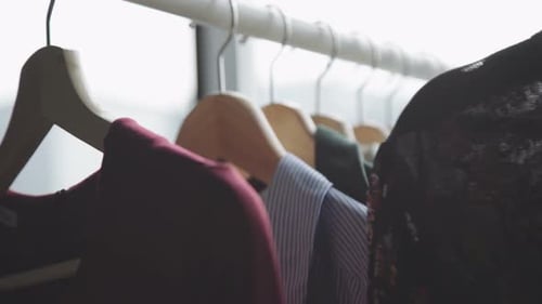 Hand Browsing Clothes on Clothing Rack Indoors