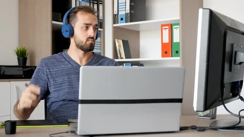 Man Working at Desk with Laptop and Drawing Tablet