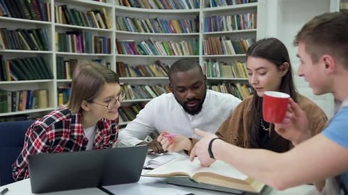 Estudiantes sentados juntos en la biblioteca y trabajando en casa