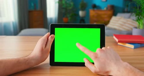 Closeup of Man Using Hand Gestures on Green Mockup Screen Digital Tablet Computer in Landscape