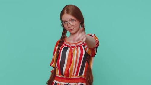 Rothaariges Mädchen zeigt in die Kamera und schaut mit verspieltem, fröhlichem Ausdruck und trifft Wahl Hey du