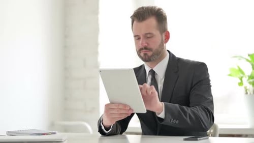 Young Businessman Using Tablet While Sitting in Office