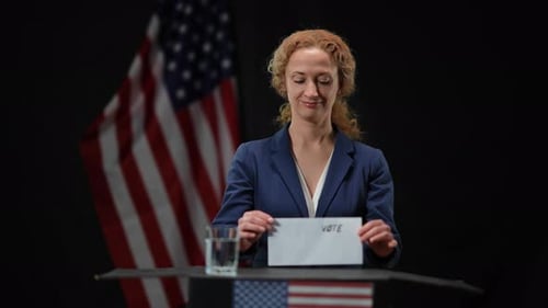 Woman Holding Vote Envelope in Front of Flag