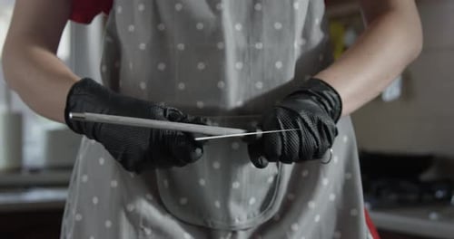 Gloved Person Sharpening Knife with Honing Steel