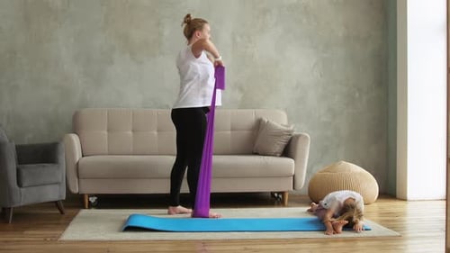 Woman Exercising With Daughter in Living Room