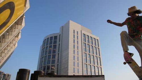 Skateboarder Performing Trick Near City Building