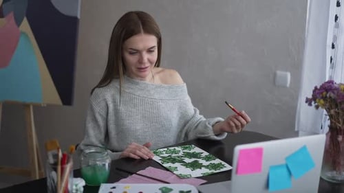 Woman Painting and Showing Artwork at Home
