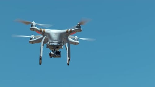 White Drone Hovering in Blue Sky
