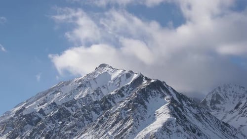 Snow Capped Mountains Against Blue Sky and Clouds