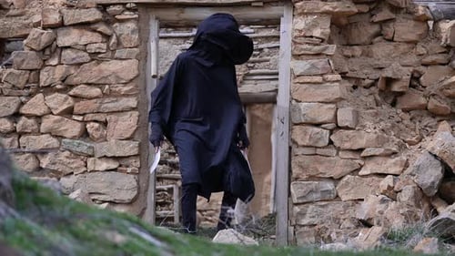 Hooded Figure with Blades Walks from Crumbling Ruins