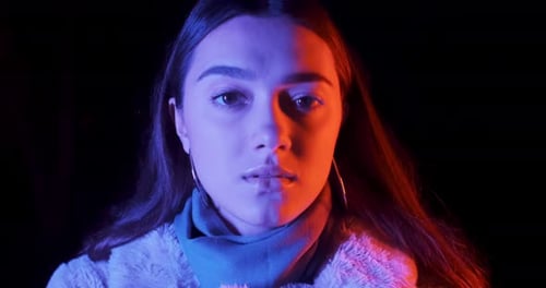 Glamorous Woman Posing with Neon Lighting at Night