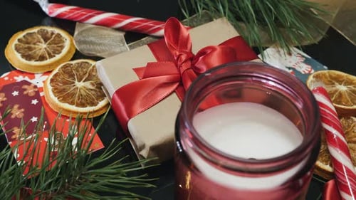 Christmas greeting card. Christmas gift box and candle in stack of presents