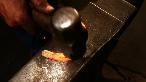 Blacksmith Forging Red Hot Horseshoe on Anvil