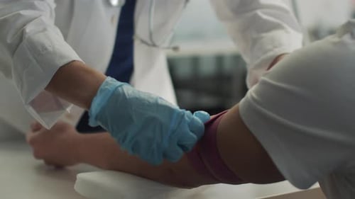 Without a Face a Laboratory Assistant in the Clinic Puts a Tourniquet on the Patients Arm and Takes