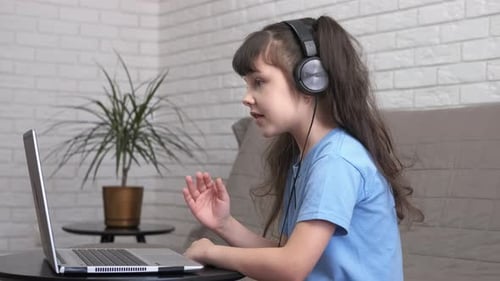 Girl Talks to Laptop with Headphones On