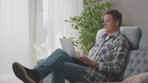 Man on Laptop Talking on Video Call at Home