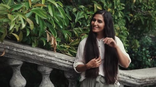 Smiling Brunette Is Standing Alone in a Garden
