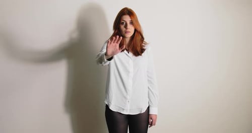 Young Woman Holding Up Hand in Stop Gesture