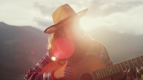 Woman Plays Guitar in Mountains at Sunrise