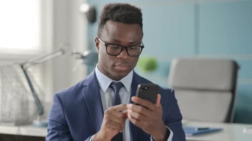 Man in Suit Uses Smartphone in Office