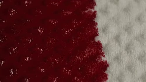 Red Liquid Spreading Across Textured White Surface