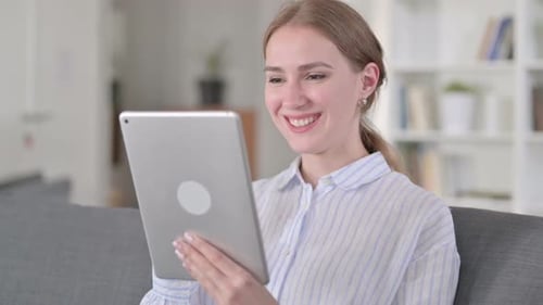 Young Woman Video Chats on Tablet at Home