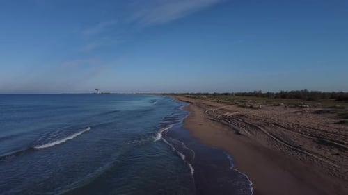 Two Travelers Stand on the Sea Beach on a Long Coastline in Bright Sunny Weather