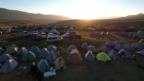 Drone View of Tent Camp Among Green Fields at Dawn