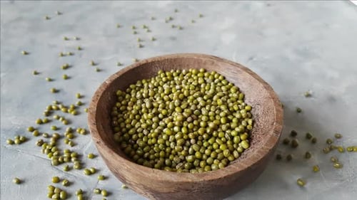 Frijoles mungo secos en un plato con una cuchara de cerca