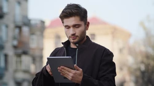Young Adult Using Tablet in Urban Setting