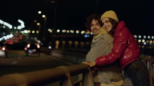 Young Couple Embracing at Night on City Bridge