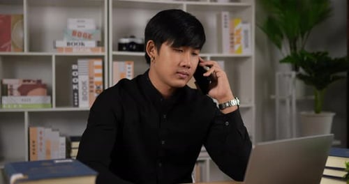 Young Adult Talking on Phone at Desk