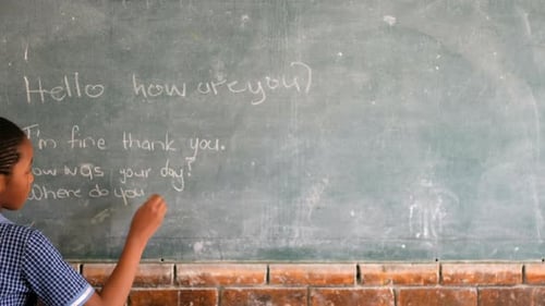 Schulmädchen schreibt auf Tafel im Klassenzimmer 4k