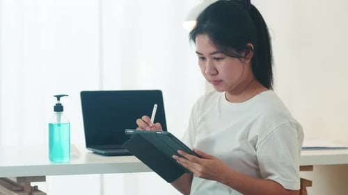 Asian woman using alcohol gel hand sanitizer wash hand before open tablet for protect coronavirus.