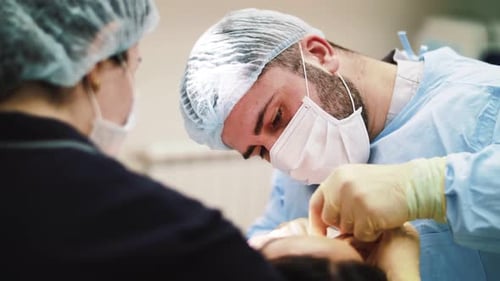 a man surgeon performs face and hands surgery close-up