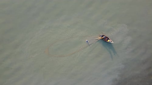 Aerial top down view two fisherman casting net