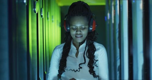 Woman Works in Data Center Wearing Headphones