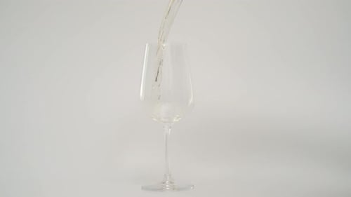 Clear Liquid Pouring into a Clear Wine Glass