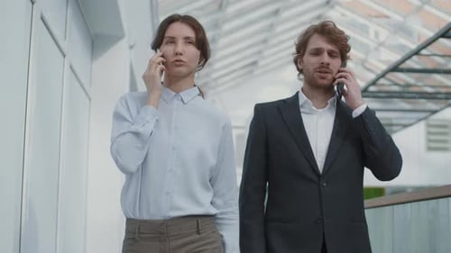Busy Business Professionals Talking on Phones in Office