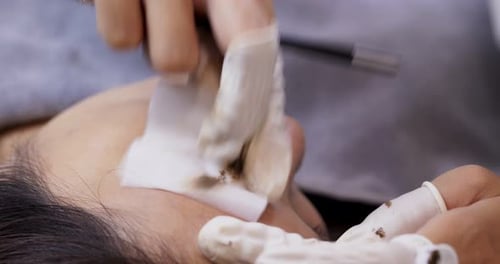 Woman Cleaning Eyebrow with Gloved Hands