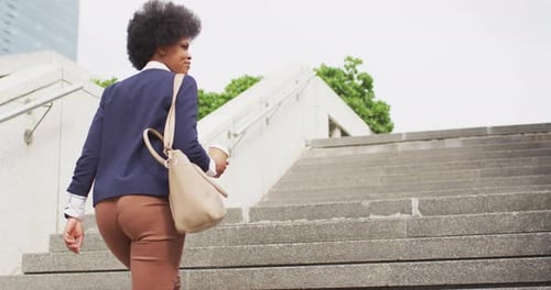 Stylish Woman Walks Up Stairs in Urban Setting