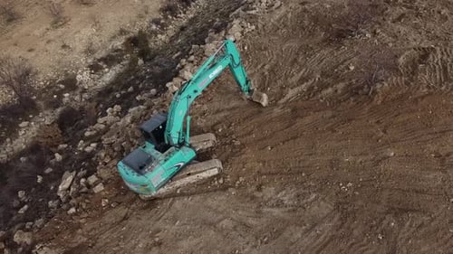 Aerial View of Excavator Digging on Hillside