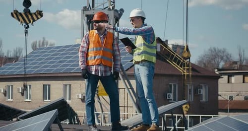 Ingeniero y técnico discutiendo entre paneles solares