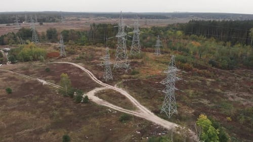 Linhas de transmissão de longa distância. Pilares de alta tensão na floresta. Postes de transmissão de energia